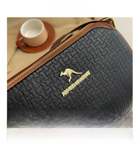 Close-up of textured pebble leather bag with gold kangaroo logo and brown trim
