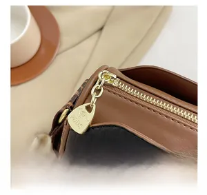 Detail of premium gold metal zipper with embossed kangaroo logo on leather Boston bag