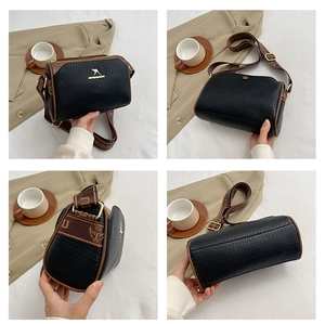 Detail view of black lychee grain leather Boston bag with golden kangaroo logo and wide strap