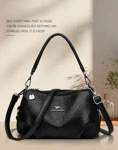 Détail de la texture grainée noire et du logo kangourou sur ce sac à bandoulière chic
