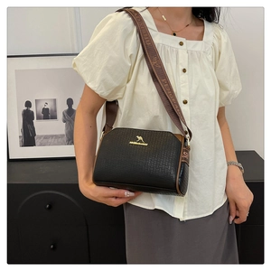 Detail of woven texture black leather Boston bag with kangaroo logo and fabric strap