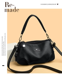 Détail d'un sac à main en cuir noir grainé avec logo kangourou doré et bandoulière