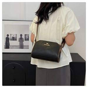 Detail of black embossed PU leather crossbody bag with logo and jacquard wide strap