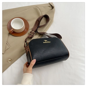 Close-up of black textured leather Boston bag with gold kangaroo logo and brown wide strap