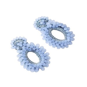 Handmade light blue seed bead oval hoop earrings in bohemian style on white background
