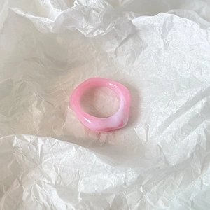 Detailed view of a pink marble resin ring featuring stylish irregular wavy patterns