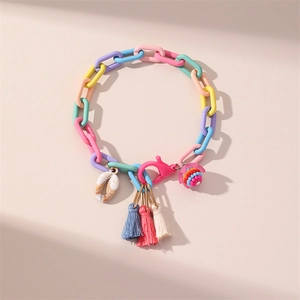 Colorful macaron chain anklet with shell and tassel charms on a beige background