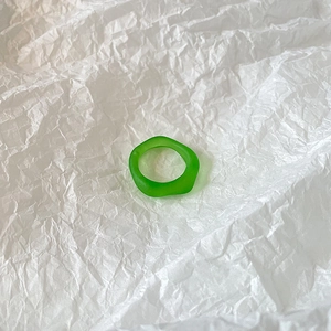Macro view of a frosted translucent emerald green resin ring with irregular geometric design