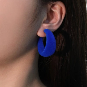 Close-up of Klein blue flocked hoop earring showing soft velvet texture on model