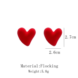 Detail view of red flocked heart earrings showing material texture and 2.6cm size