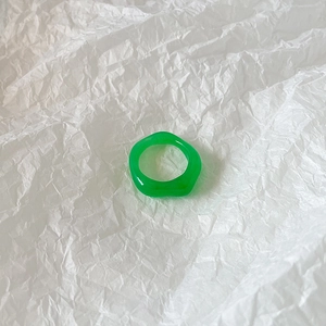 Detailed view of translucent emerald green resin ring with irregular art design