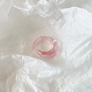 Detail shot of a transparent pink resin ring with a candy-like jelly texture on white paper