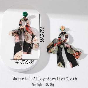 Detail of floral chiffon tassel earrings with green beaded accents and alloy base