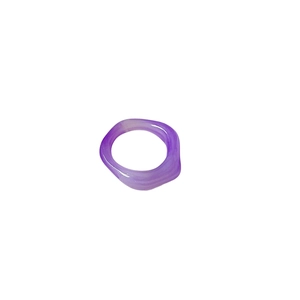 Macro detail of a translucent purple resin ring with natural marble texture on white background