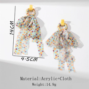 Detail of long blue polka dot fabric tassel earrings with yellow acrylic rings