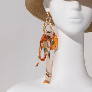 Bohemian long tassel earrings with amber resin ring and floral silk ribbons on model