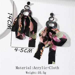 Detail view of long floral fabric tassel earrings with dark acrylic geometric rings