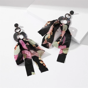 Detail of long black hoop earrings featuring elegant floral chiffon fringe ribbons