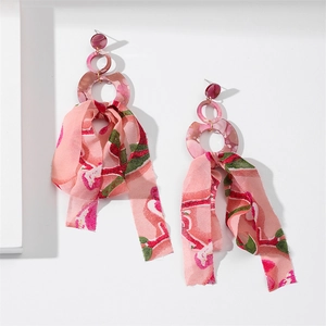 Detail of long drop earrings with pink resin rings and floral chiffon ribbon tassels