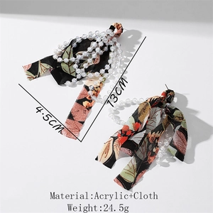 Detail view of floral fabric bow earrings with clear acrylic bead chains and size info