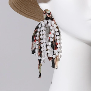 Detail of bohemian long tassel earrings with white beads and vintage floral ribbons