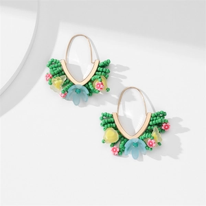Vue détaillée de boucles d'oreilles en perles faites main avec petites fleurs en résine