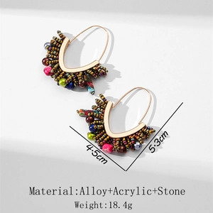 Détail de boucles d'oreilles créoles bohèmes faites main avec perles et pendentifs en pierre