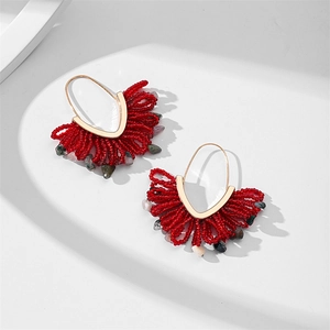 Détail de boucles d'oreilles bohèmes en perles rouges faites main avec franges en pierre