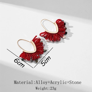 Détails de boucles d'oreilles en perles faites main avec glands rouges et pierres