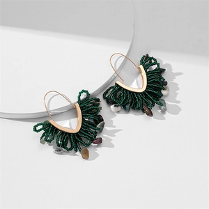 Détail de boucles d'oreilles en perles vertes faites main avec franges en pierre naturelle