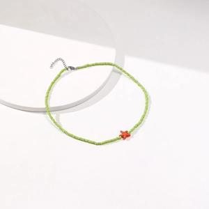 Detailed shot of green bead choker with orange starfish pendant and silver clasp