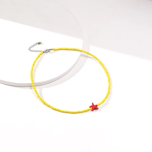 Detail of yellow seed bead choker with red starfish pendant and silver extender chain