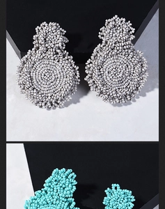 Detail of bohemian handmade seed bead earrings in grey and blue geometric patterns