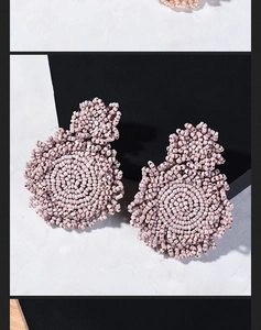 Detail of bohemian handmade beaded hoop earrings in elegant morandi purple texture