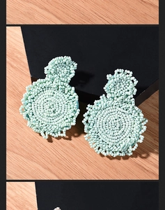 Detail of mint green handmade beaded earrings with bohemian woven seed bead fringe