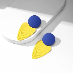 Détails des boucles d'oreilles feuilles bleu et jaune avec texture mate et motifs