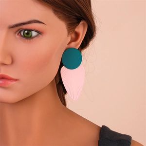 Gros plan de boucles d'oreilles feuilles avec disques bleu sarcelle et pétales texturés