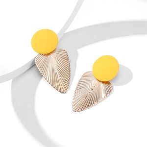 Détail de boucles d'oreilles feuille avec puces jaunes et pendentifs dorés texturés