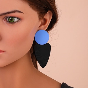 Gros plan de boucles d'oreilles géométriques avec des formes de feuilles bleues et noires