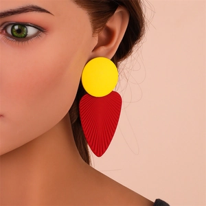 Détail de boucles d'oreilles pendantes feuilles jaune et rouge avec fini texturé