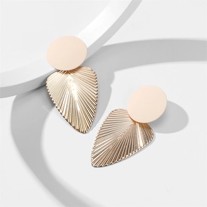 Détail de boucles d'oreilles feuilles en métal doré texturé avec clou beige