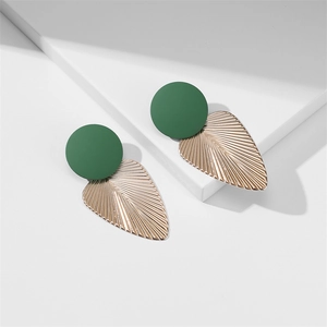 Détail d'accents vert foncé sur des boucles d'oreilles feuilles dorées texturées