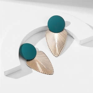 Gros plan de boucles d'oreilles vert mat avec détails en métal doré en éventail