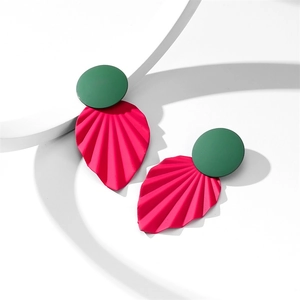 Gros plan de boucles d'oreilles feuilles vert foncé et rose vif avec texture plissée