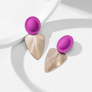 Détail macro de boucles d'oreilles ovales violettes mates et feuilles dorées en alliage