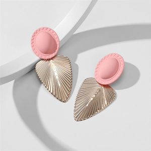 Détail de boucles d'oreilles roses mates avec pendentifs feuilles dorées sur présentoir blanc