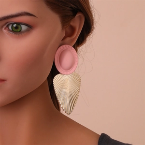 Gros plan de boucles d'oreilles feuilles roses et dorées portées par un mannequin de profil