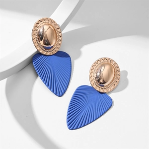 Détail de boucles d'oreilles bicolores avec métal or rose et texture en éventail bleu marine