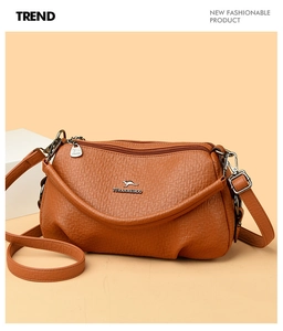 Détail du sac à bandoulière en similicuir grainé orange-brun avec logo kangourou en métal