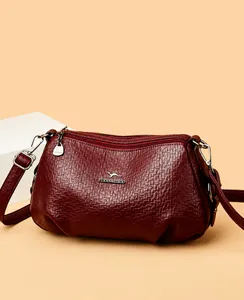 Détail du sac bandoulière bordeaux en cuir grainé avec logo kangourou et double fermeture éclair